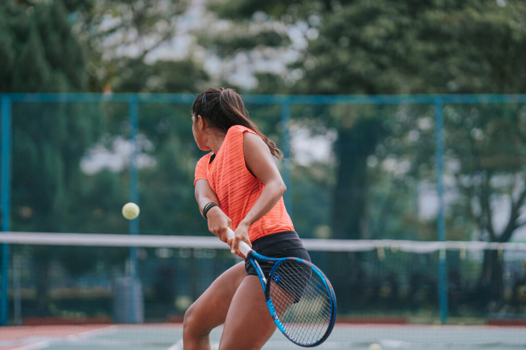 Female tennis player demonstrating tennis power exercises on the court