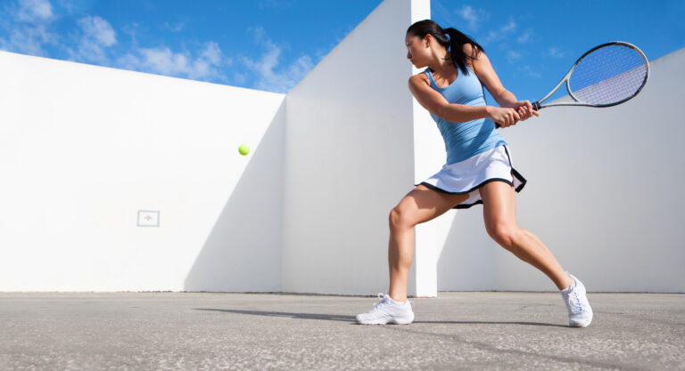 Girl Practicing A Backhand Against the Wall